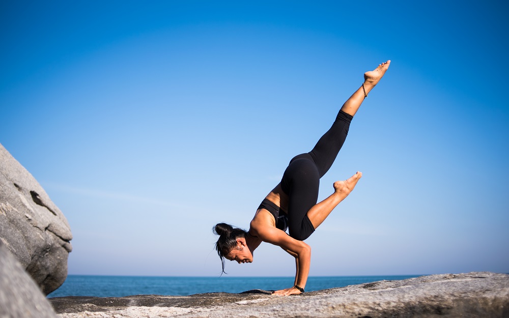 woman doing a yoga pose, standing on her arms